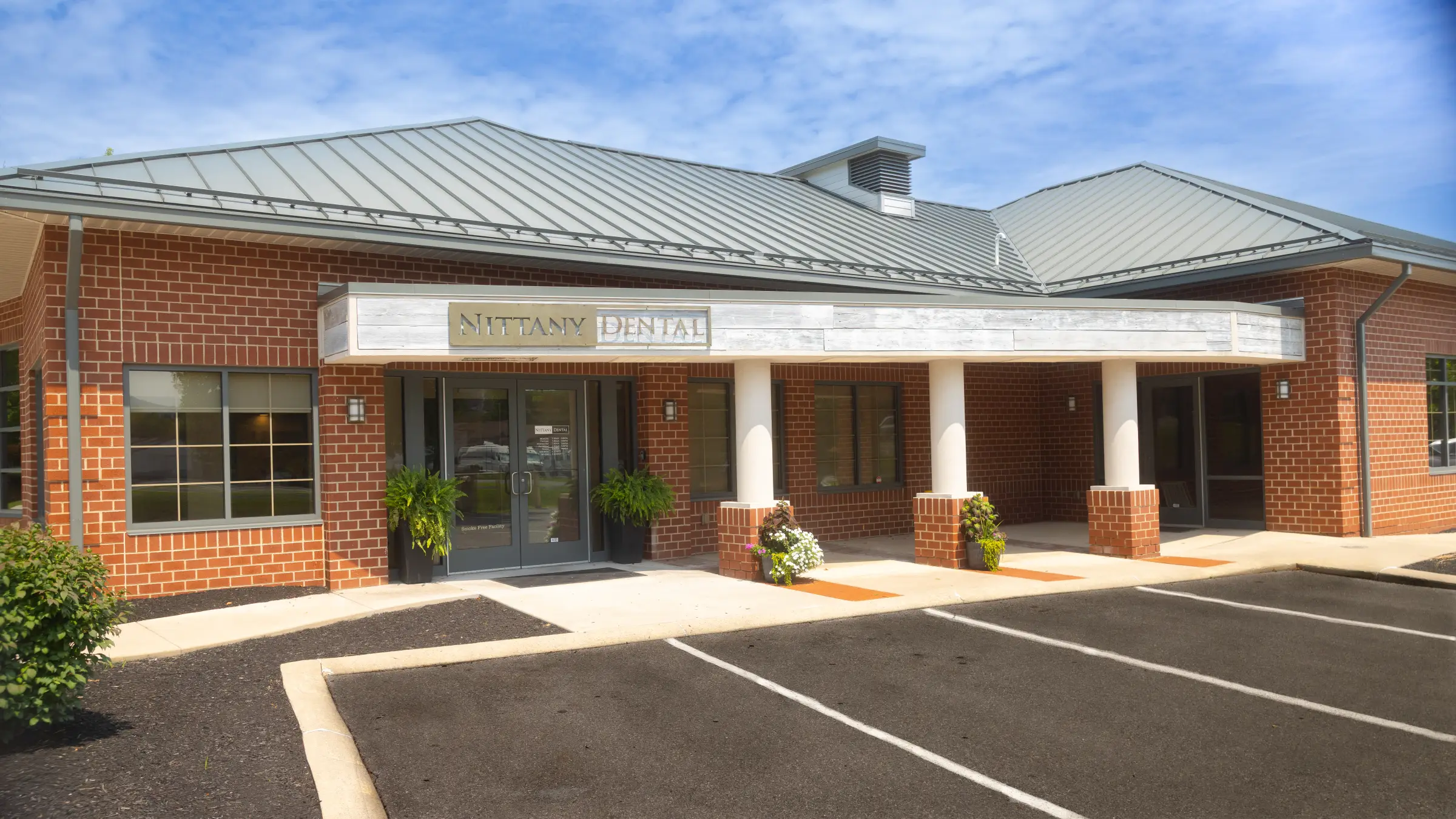 The Nittany Dental Associates building, a brick office with the practice sign over the entrance